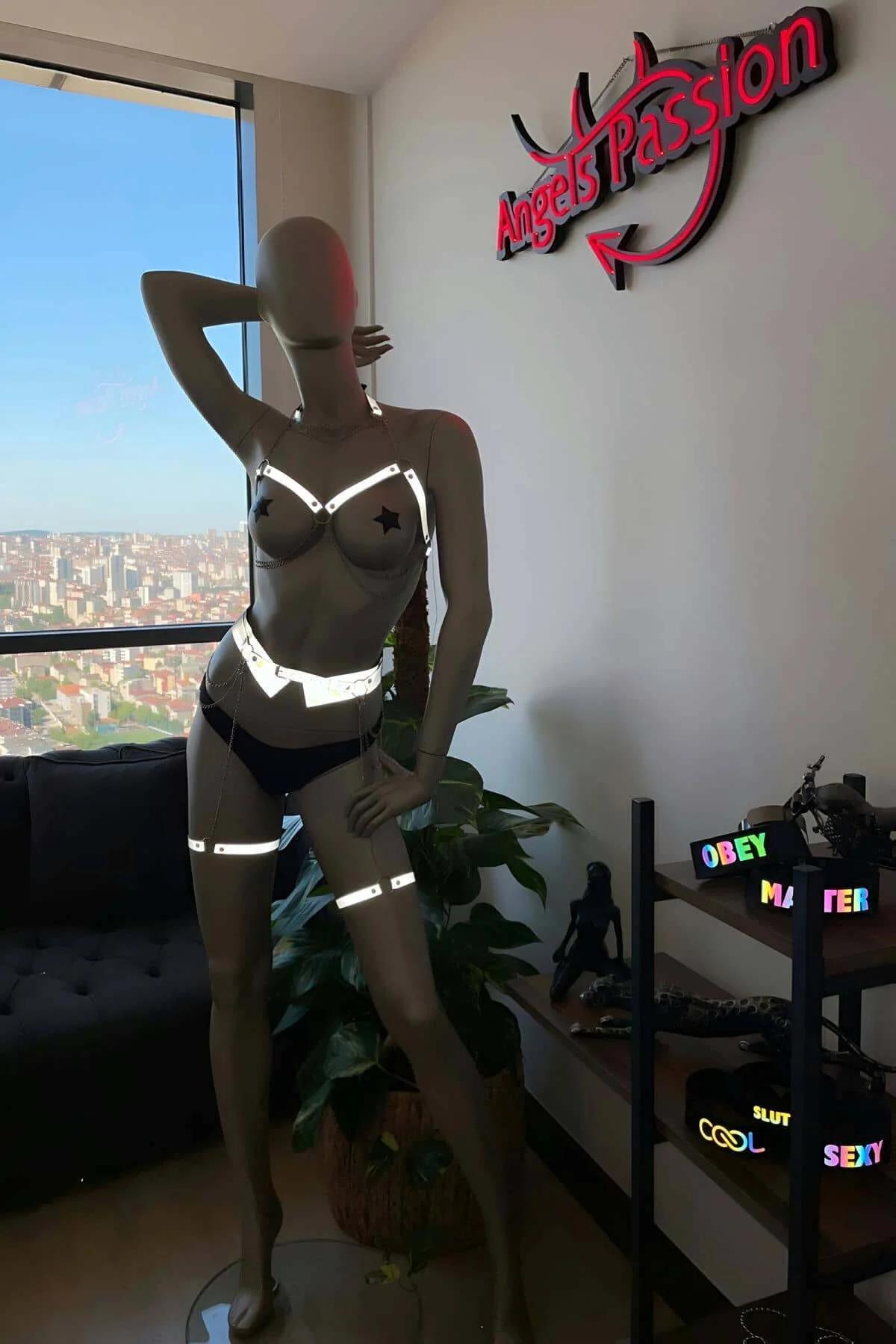 Koyu arka planda metal donanımlı beyaz reflektör harness uyluk bandı detayı