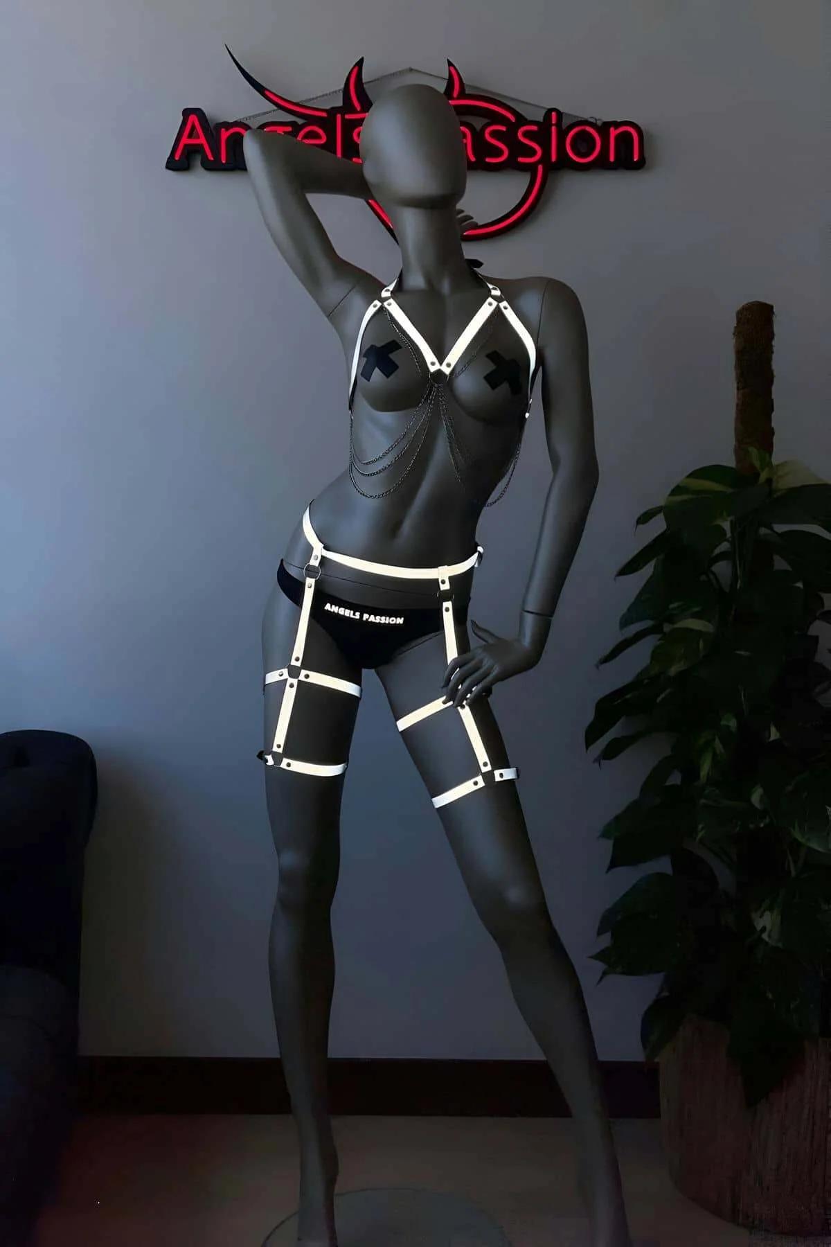 Neon aydınlatmalı ortamda birlikte giyilen göğüs ve uyluk parçalarını gösteren tam iki parçalı reflektör harness seti