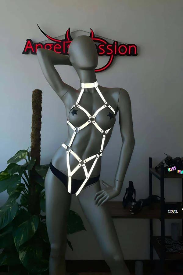 Gri manken üzerinde yıldız şekilli gümüş donanımlı beyaz reflektör tam vücut harness, boyundan başlayan geometrik kafes strap tasarımı