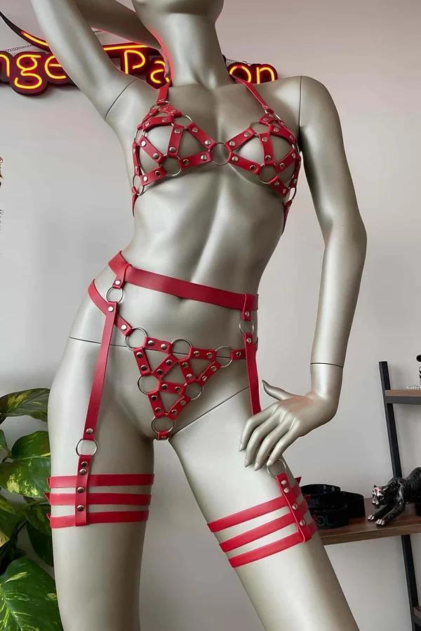 Manken üzerinde gümüş donanımlı kırmızı suni deri kafesli O-halka vücut harness ve jartiyer seti, dört parçalı görünüm