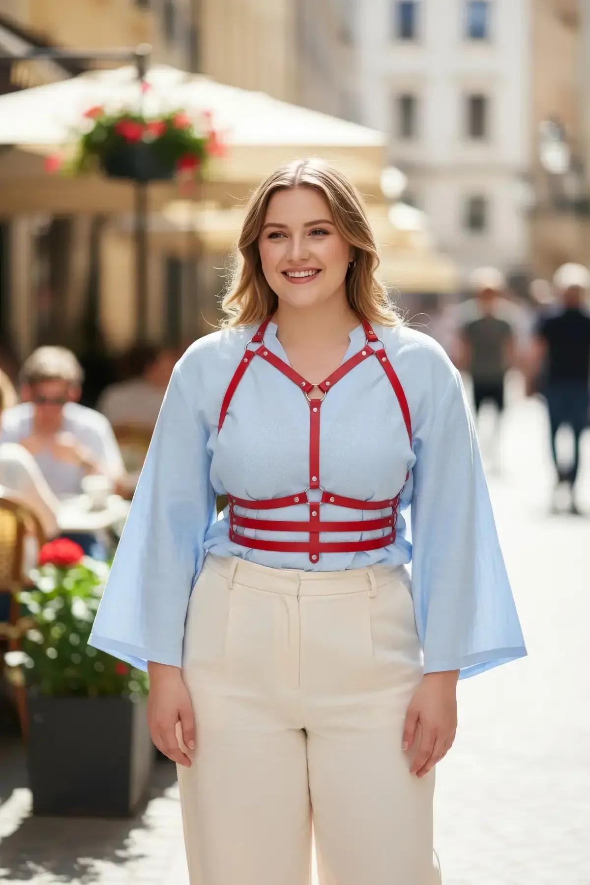 açık mavi bluz üzerine altın perçin zımbalarla kırmızı suni deri kafesli overbust vücut harness
