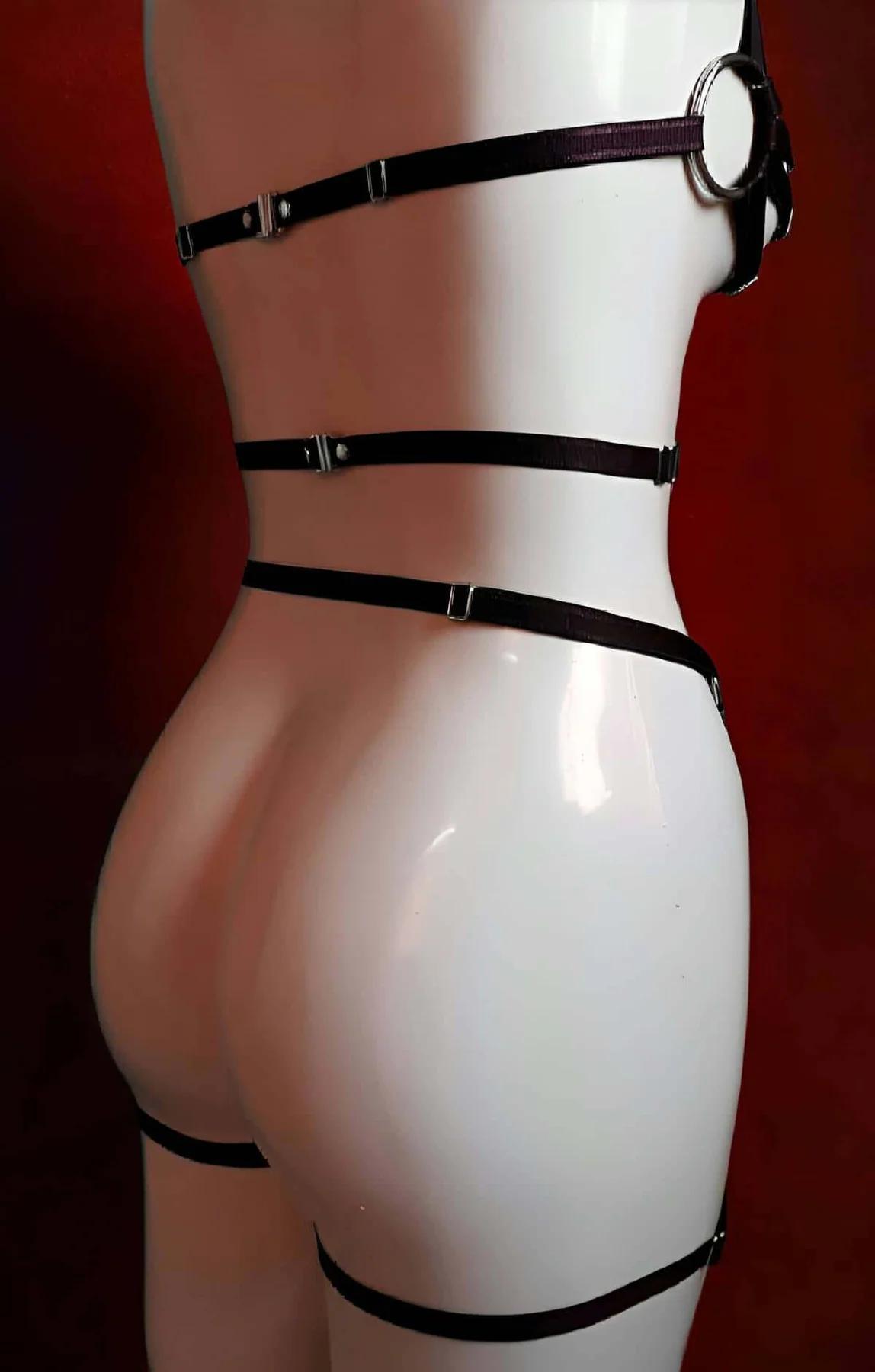 streç band genişliği ve altın metal donanımı gösteren deri üzerinde katmanlı tam gövde siyah harness