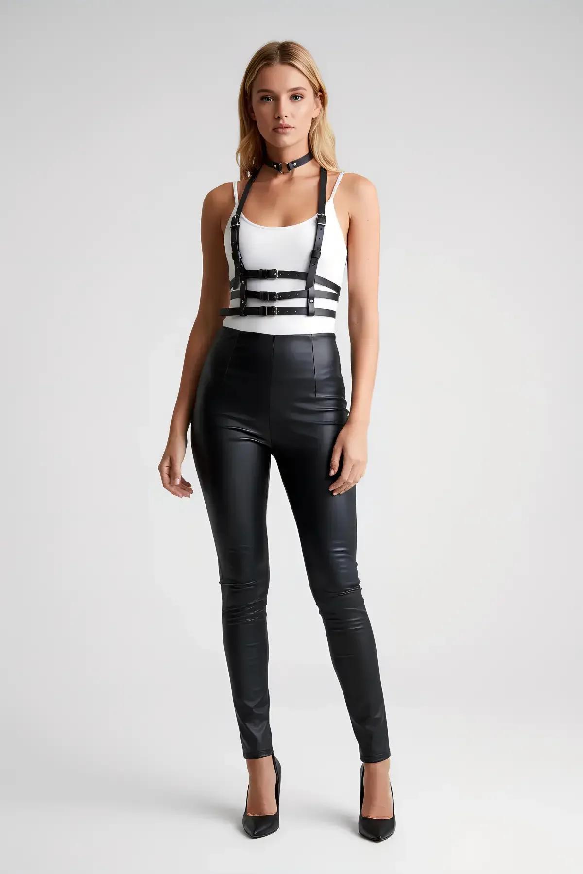 Siyah harness aksesuar beyaz crop top ve siyah tayt üzerine kombinlenmiş tam boy görünüm