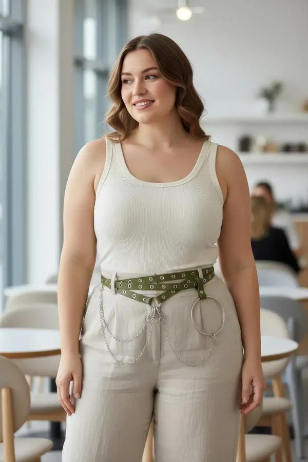 bej geniş paça pantolon üzerine çift perçin sırası sarkıt gümüş zincir ve büyük O-halkayla zeytin yeşili suni deri kemer harness