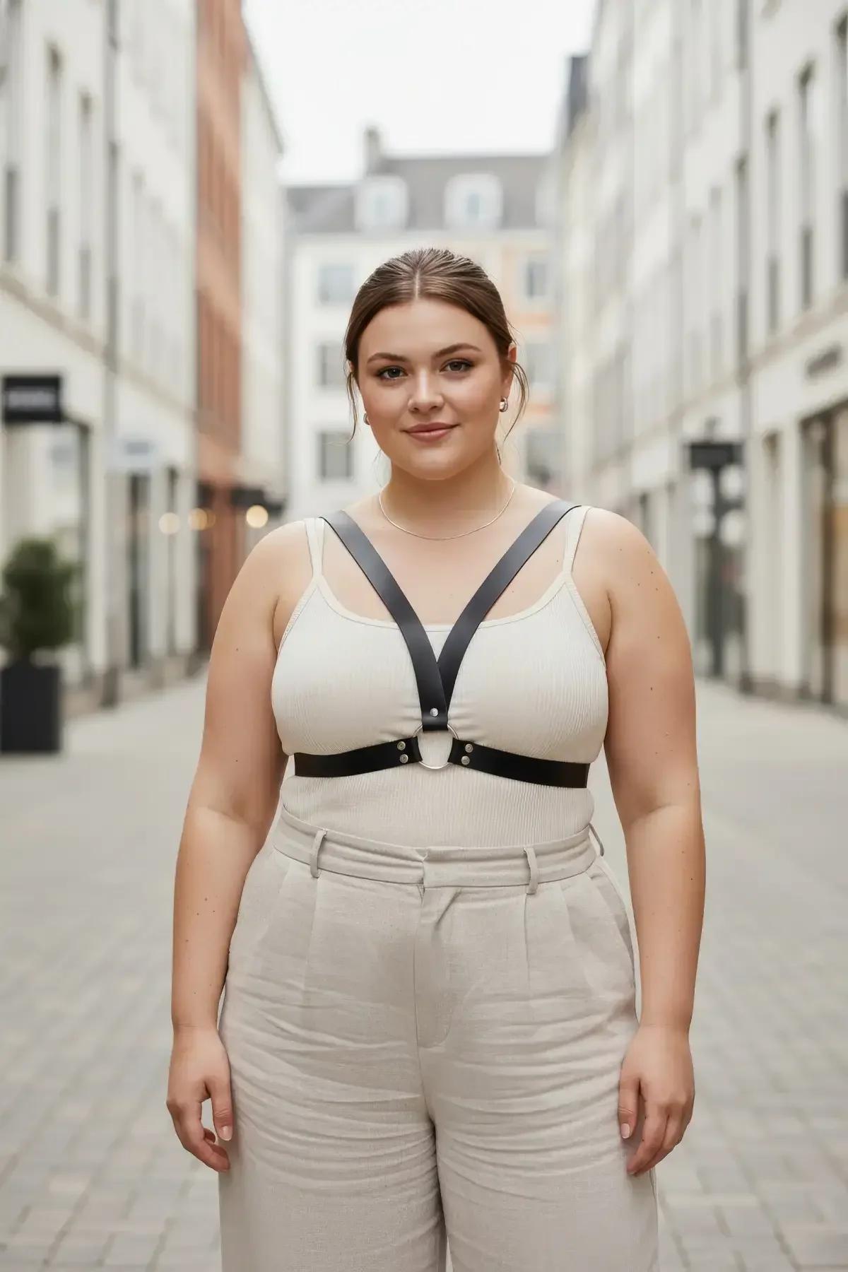 beyaz üst üzerine giyilmiş gümüş O-halka ve göğüs altı bantlı siyah suni deri minimalist göğüs harness