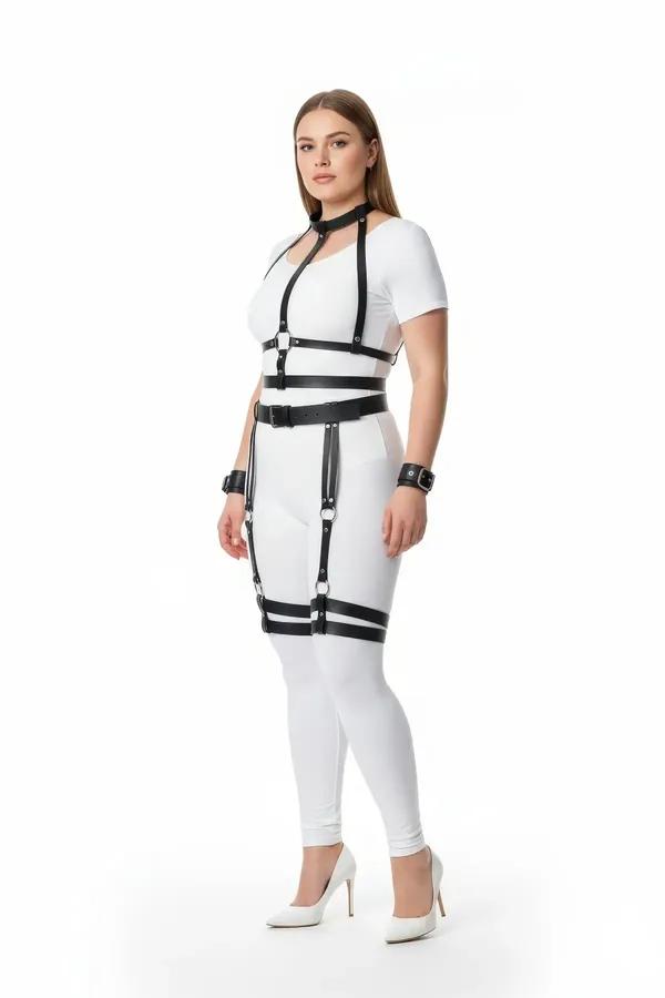 Göğüs kafesi, bel kemeri, uyluk jartiyerleri ve bilek manşetleriyle siyah suni deri tam vücut harness seti, beyaz kıyafet üzerinde