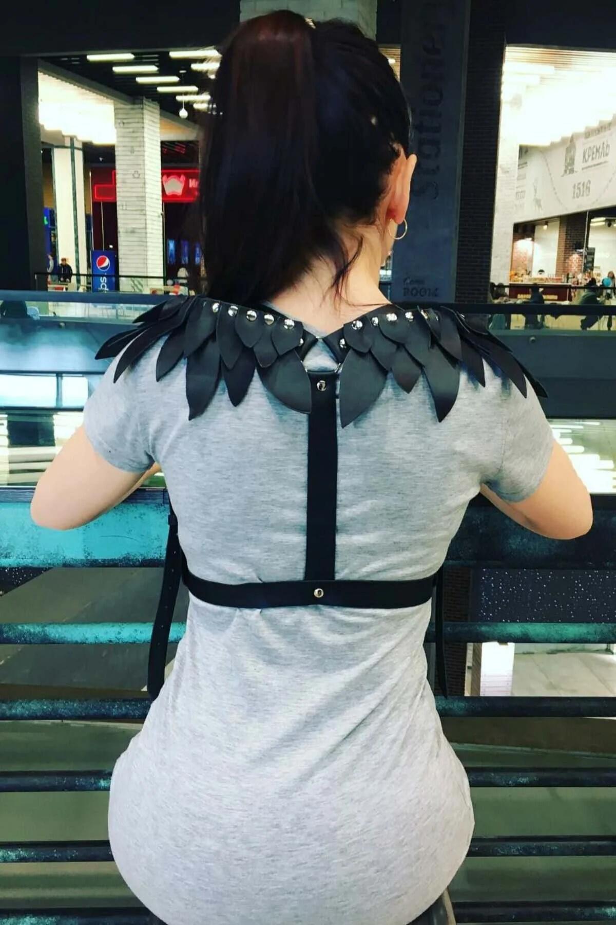 gri tişört üzerinde gümüş kubbe zımba ve ayarlanabilir arka askılı siyah suni deri kanatlı omuz harness