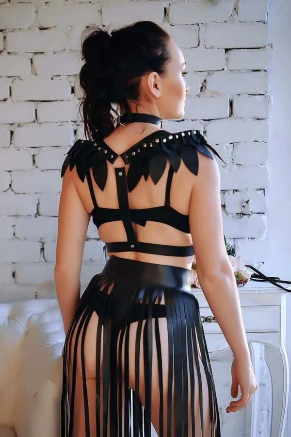 uzun püsküllü etek ile eşleştirilmiş, zımbalı apoletler ve çok askılı arka gösteren siyah suni deri kanatlı omuz harness arka görünüm