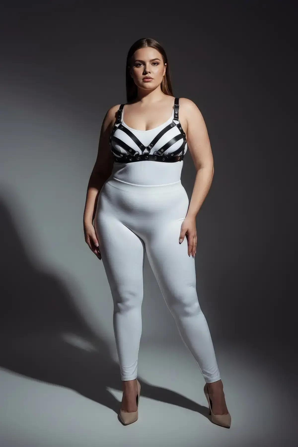 Beyaz bodysuit üzerine katmanlı gümüş toka bantlı siyah suni deri kafesli göğüs harness sütyen