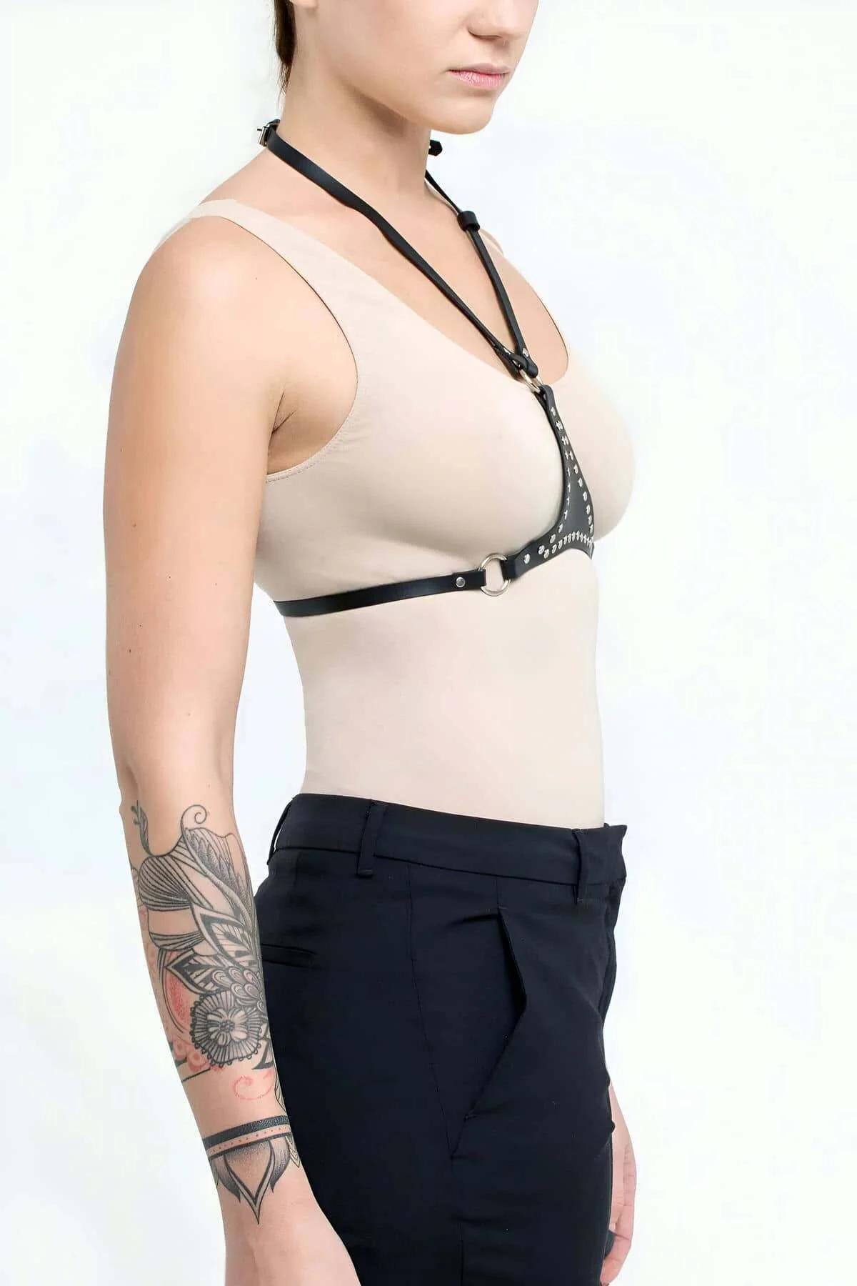 Siyah PU deri harness ön bantlarındaki gümüş tonlu preslenmiş metal zımbaların yakın çekimi