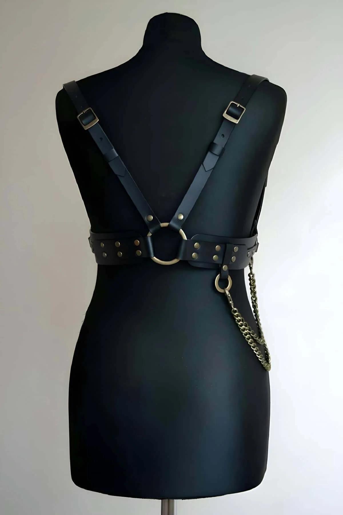 Mankende antik bronz O-halka perçin zimbaları ve zincir sarkıtlı siyah suni deri vücut harness arka görünümü
