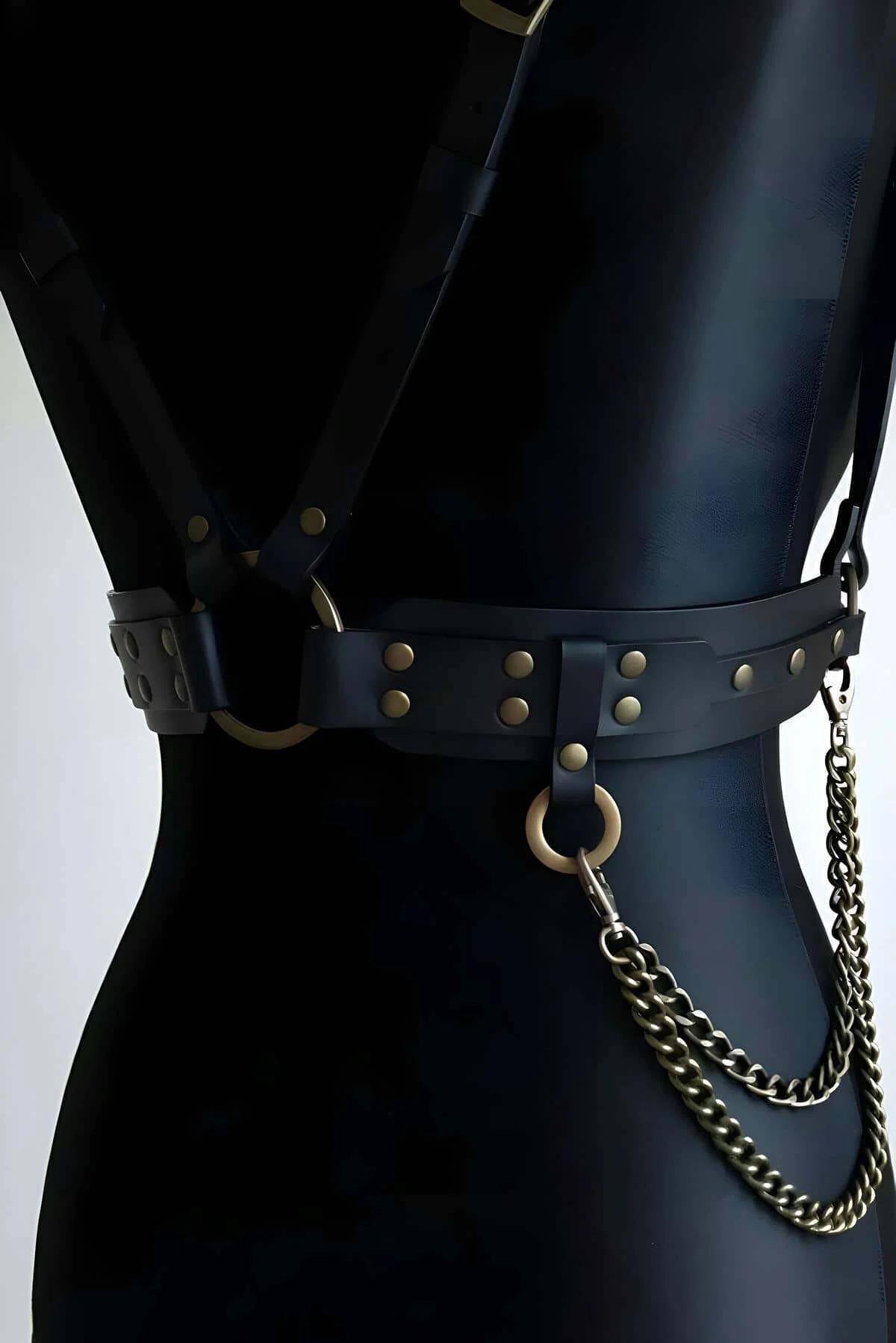 V şekilli omuz askıları ve bronz donanımlı underbust bandını gösteren siyah suni deri göğüs harness önden görünüm