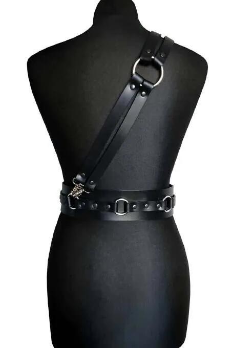 Manken üzerinde gümüş D-halka aksan ile siyah suni deri omuz ve bel harness, arkadan görünüm