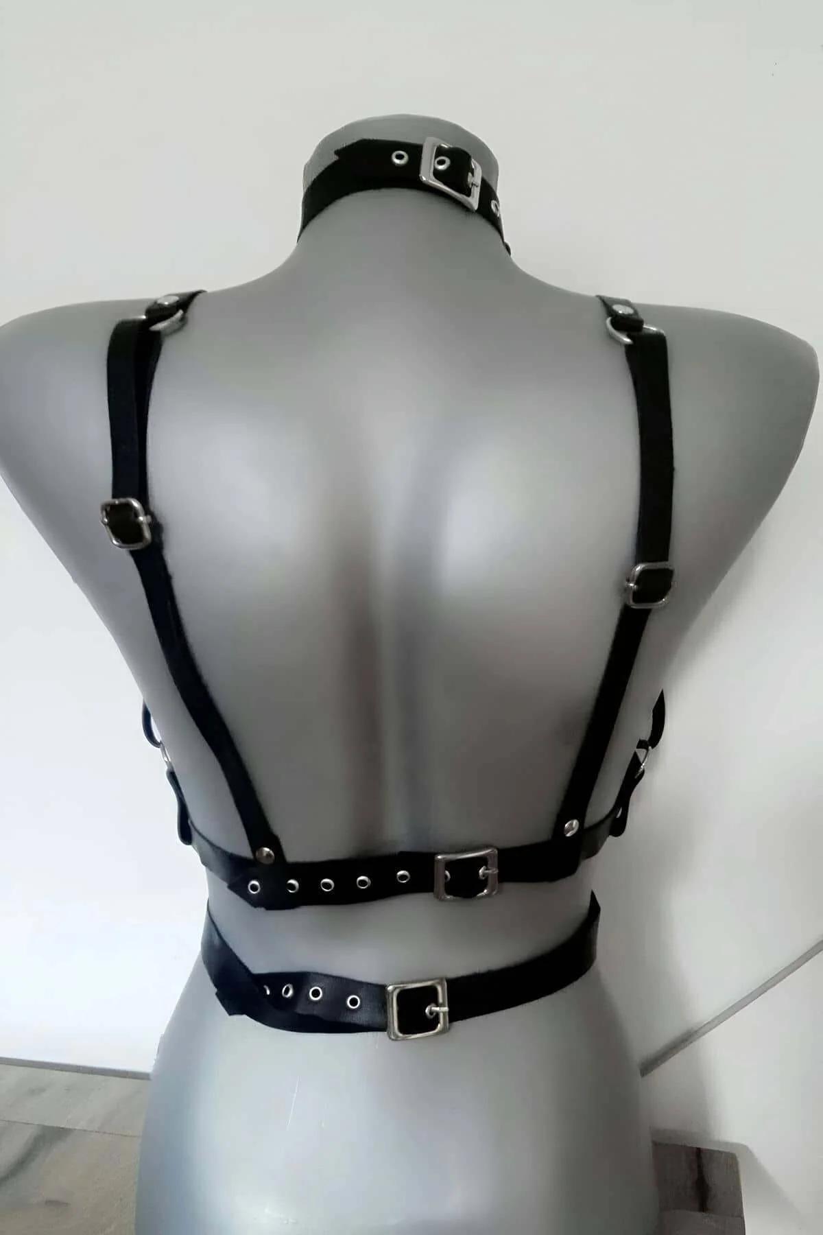 Dört ayarlanabilir iğne toka askısı gösteren siyah mat suni deri göğüs harness, düz yatış
