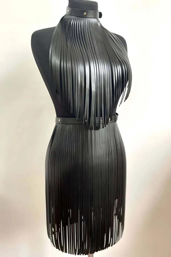 manken üzerinde siyah suni deri püsküllü halter top ve mini etek seti, çoker boyunluk ve ayarlanabilir bel kemeri