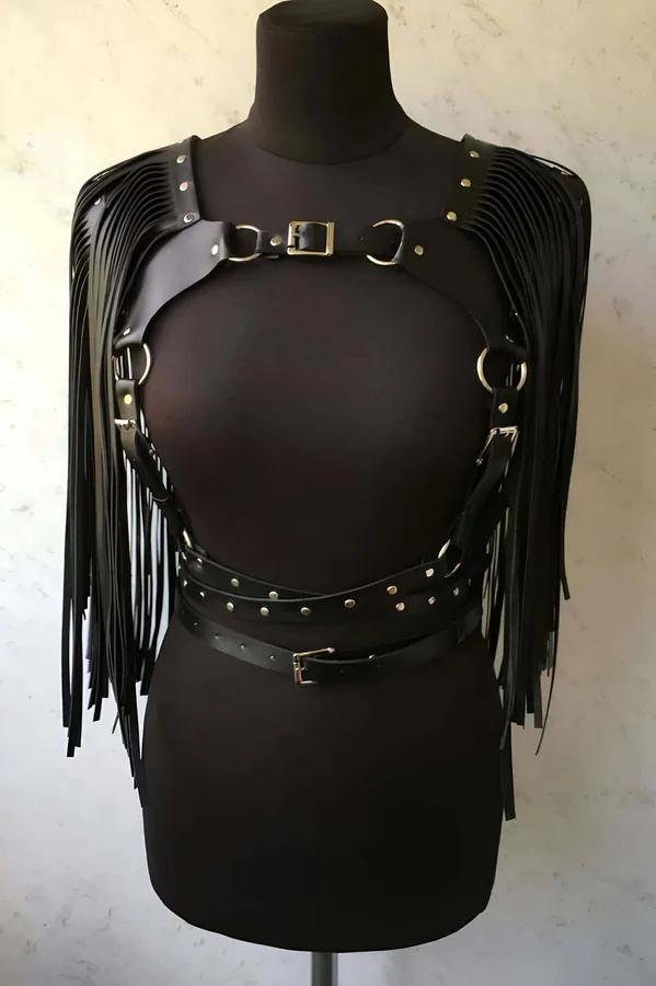 manken üzerinde siyah suni deri püsküllü vücut harness, gümüş O-halkalar ve zımbalı bel kemeri