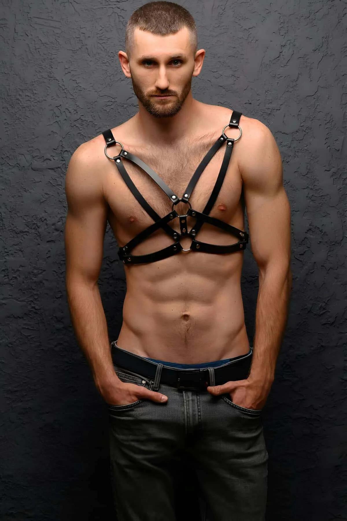 Erkek modelde üç gümüş O-halka ve X-çapraz askı konfigürasyonlu siyah suni deri göğüs harness