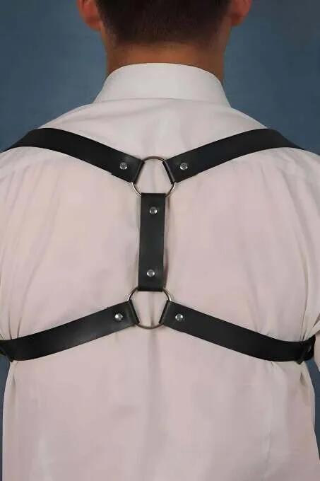 Beyaz gömlek üzerinde çift gümüş O-halkalı ve X-askı yapılı siyah suni deri sırt harness