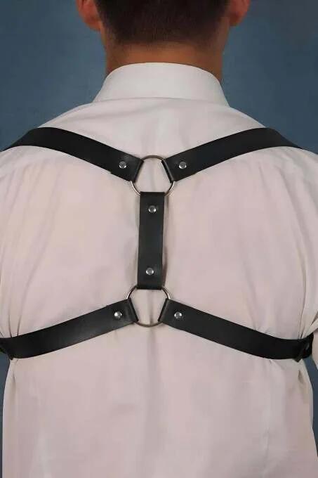 Beyaz gömlek üzerinde çift gümüş O-halkalı ve X-askı yapılı siyah suni deri sırt harness