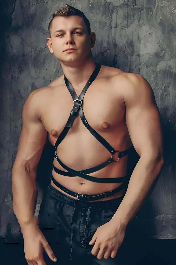 Erkek model tarafından giyilen gümüş tokalar ve O-halkalı siyah suni deri göğüs ve gövde harness