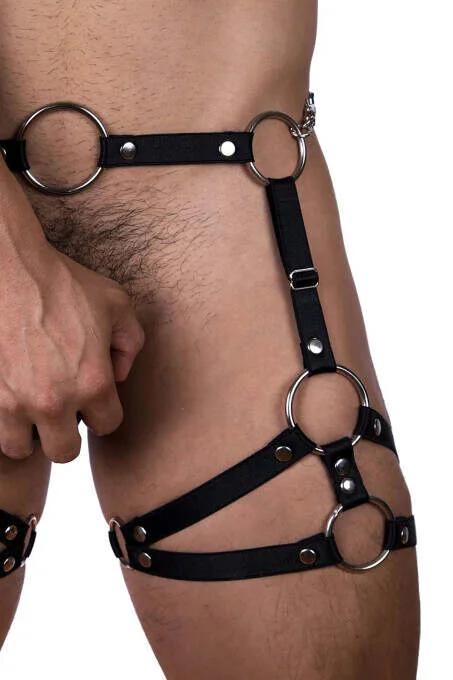 Kalça ve uylukta giyilmiş beş gümüş O-halka ve çıkarılabilir zincir halkası ile siyah suni deri erkek vücut harness'ı