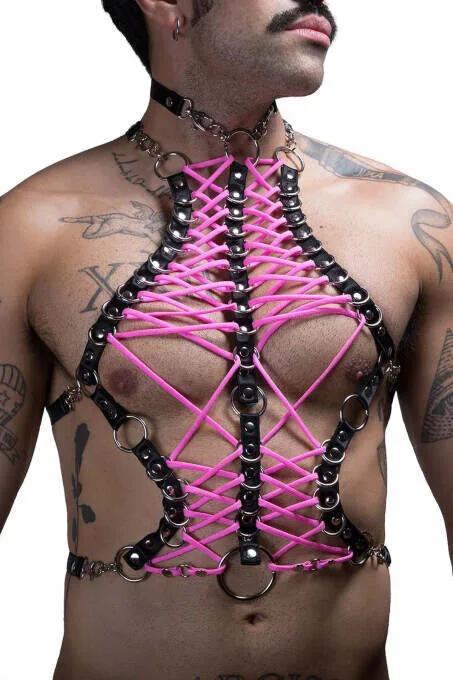 Adam tarafından giyilen neon pembe çapraz bağcıklı ve gümüş O-halkalı siyah suni deri göğüs harness'ı