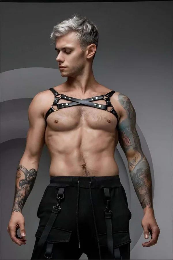 Erkek model tarafından giyilmiş gümüş O-halkalı çapraz X-askı tasarımlı siyah suni deri göğüs harness