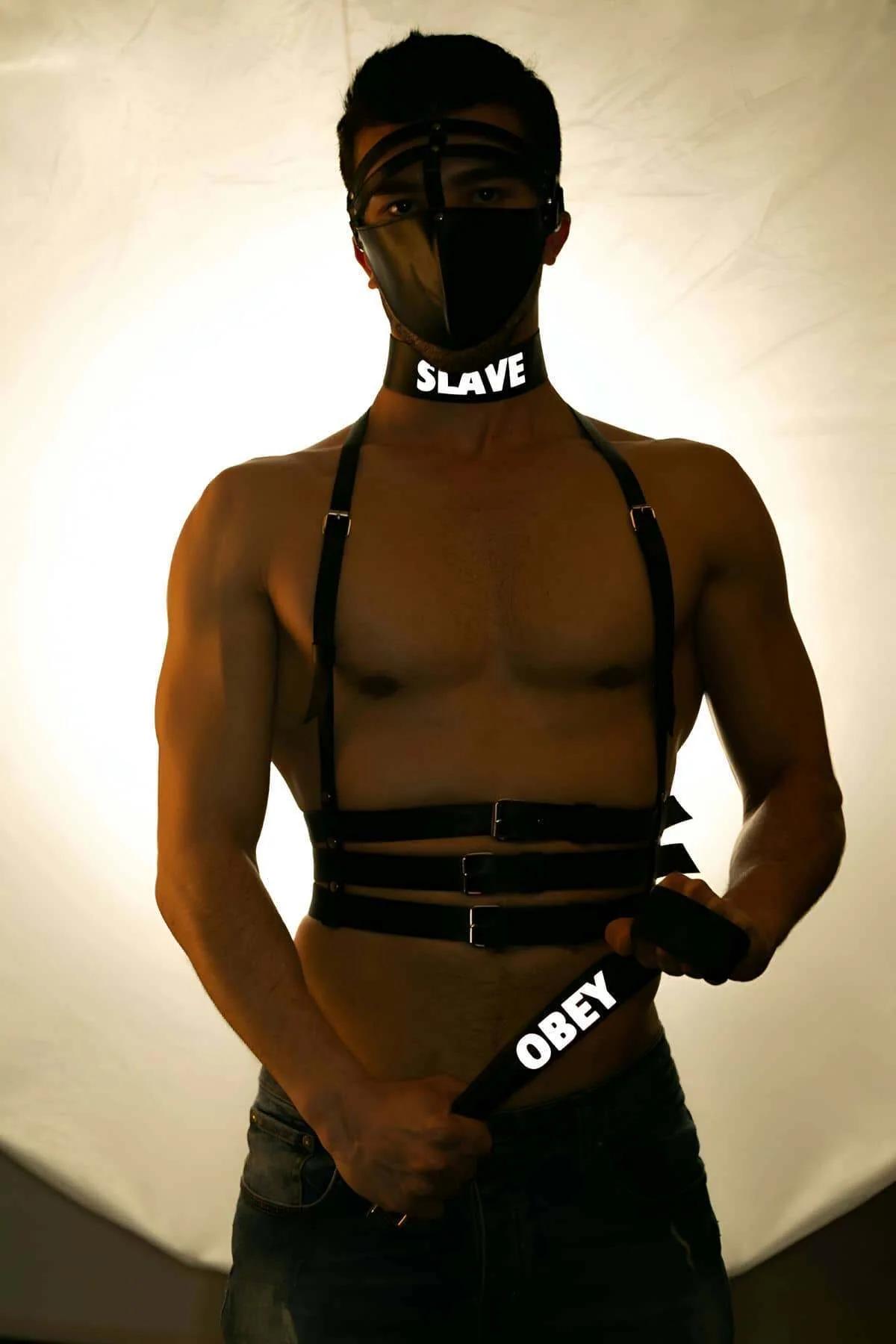 Siyah reflektörlü erkek vücut harnessi SLAVE choker ile birlikte, PU bantlar ve metal tokalar, ön görünüm