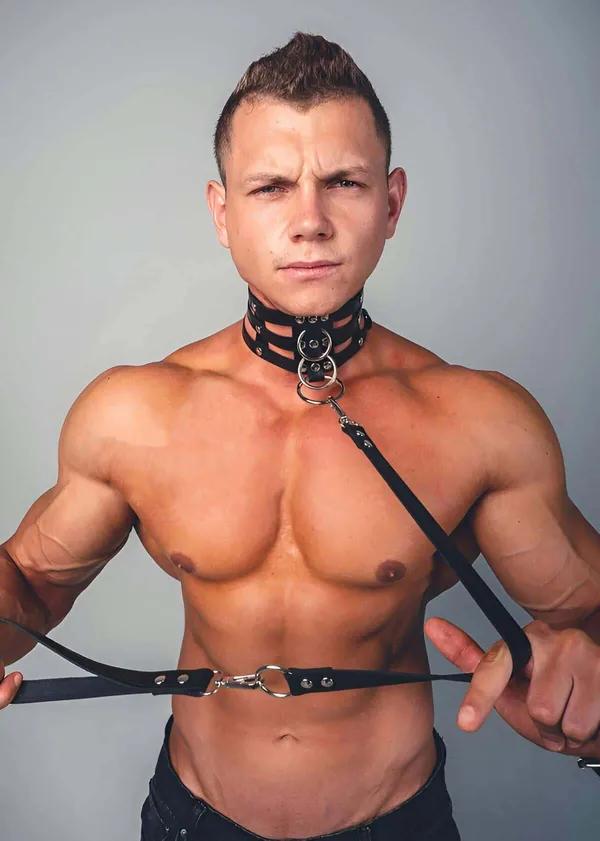 Erkek model tarafından giyilen yığılmış boyunluk askıları ve gümüş O-halkalı siyah suni deri dörtlü askılı vücut harness