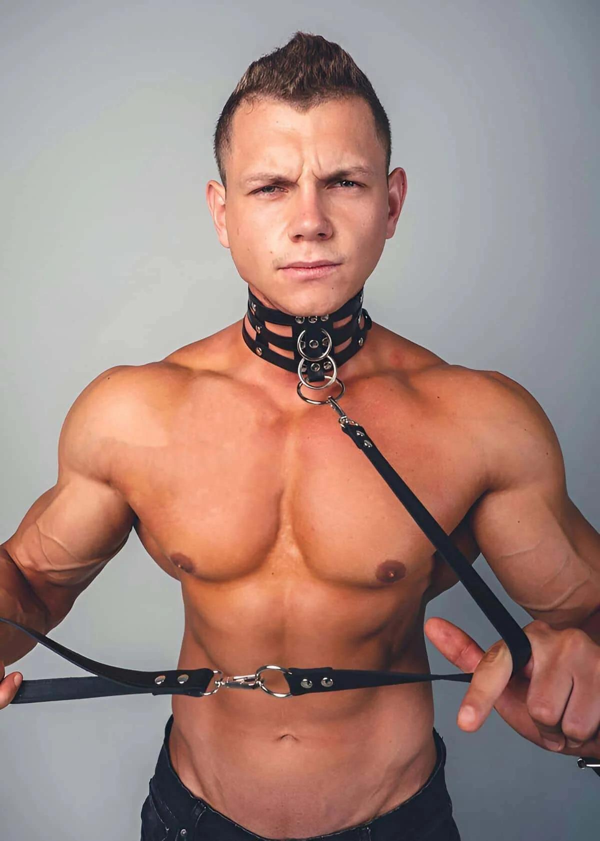 Erkek model tarafından giyilen yığılmış boyunluk askıları ve gümüş O-halkalı siyah suni deri dörtlü askılı vücut harness