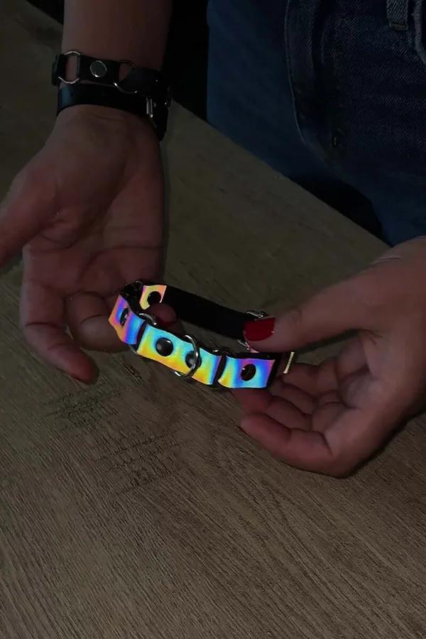 Ellerde tutulan gümüş O-halka ağızlıkları ve siyah suni deri arka yüzlü reflektör gökkuşağı holografik çoker