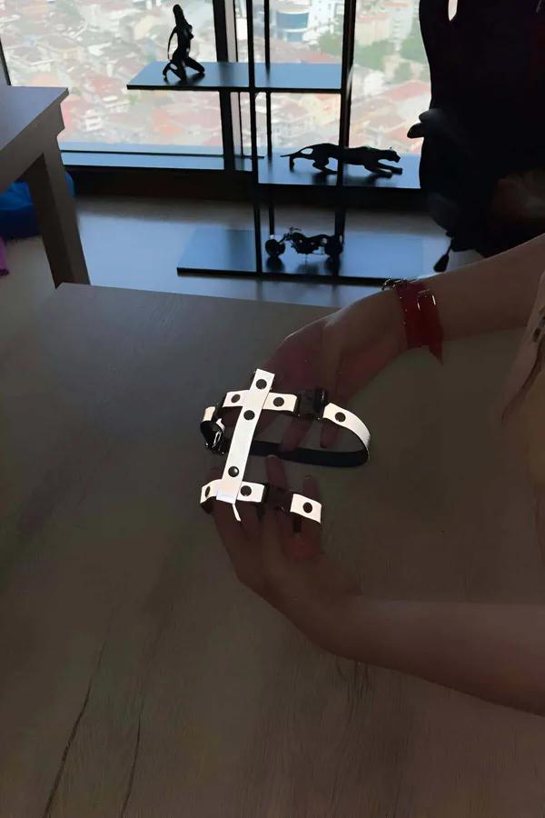 Elde tutulan siyah ayarlanabilir askılar ve delik panelli gümüş reflektör X deseni vücut harness